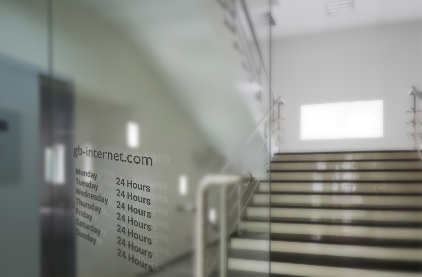 Glass door with opening times etched at eye level leading to a brightly lit wide staircase
